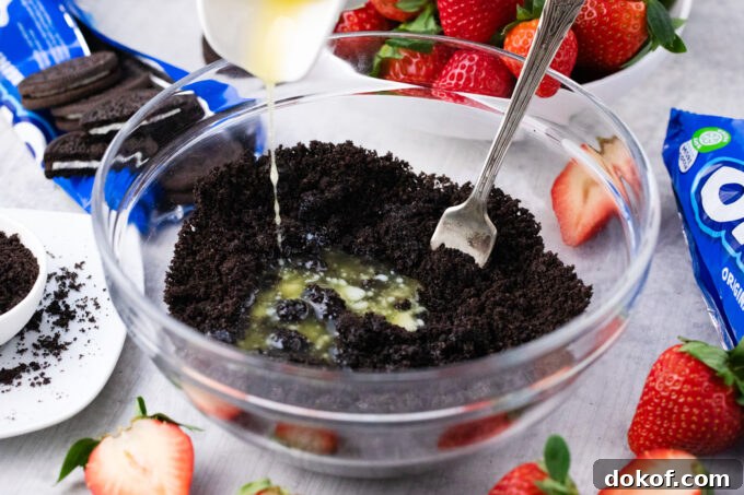 Mixing crushed Oreos and butter.