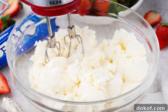 Beating cream cheese.