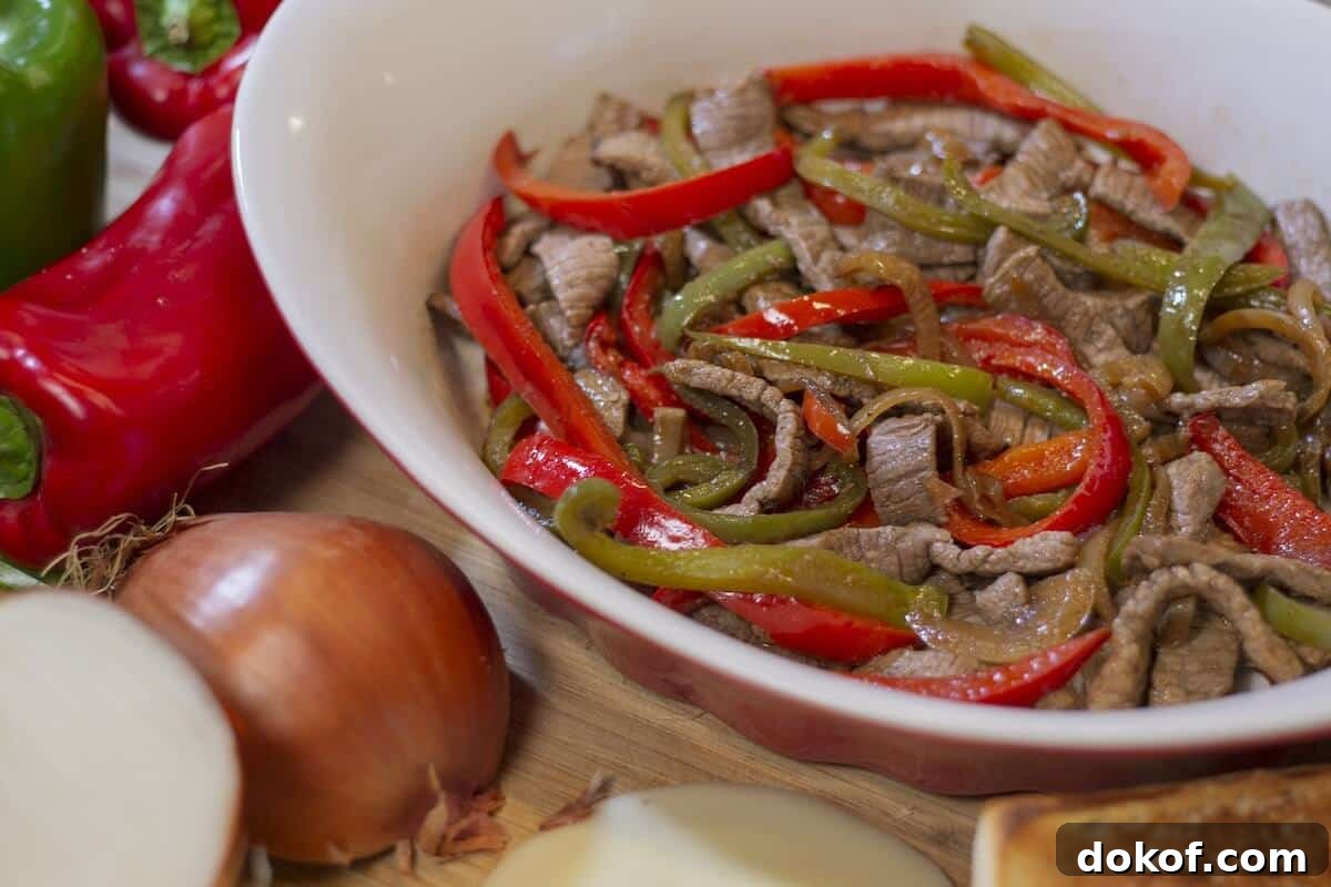 Cooked onions and peppers with grilled beef.
