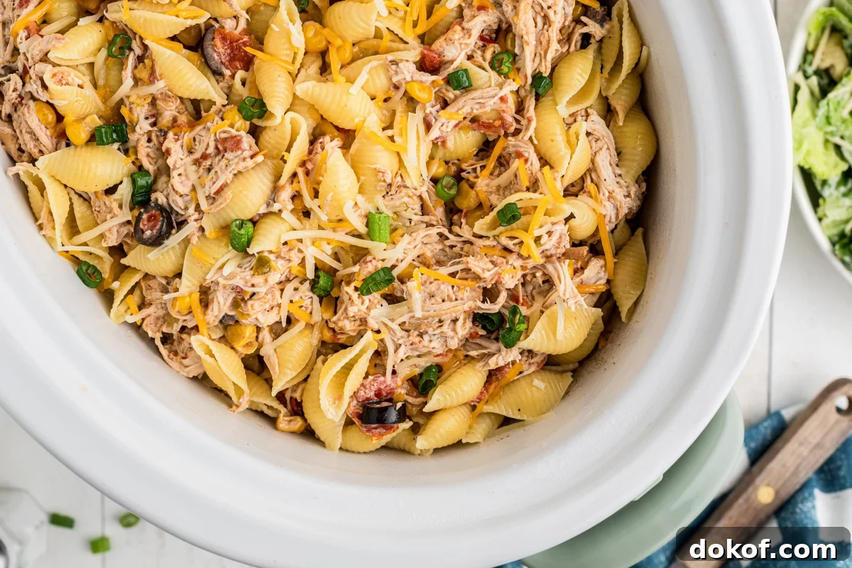 Southwestern Cheesy Chicken Pasta Bake with Roasted Corn and Peppers 7 overhead close-up of southwestern cheesy chicken pasta in a slow cooker.