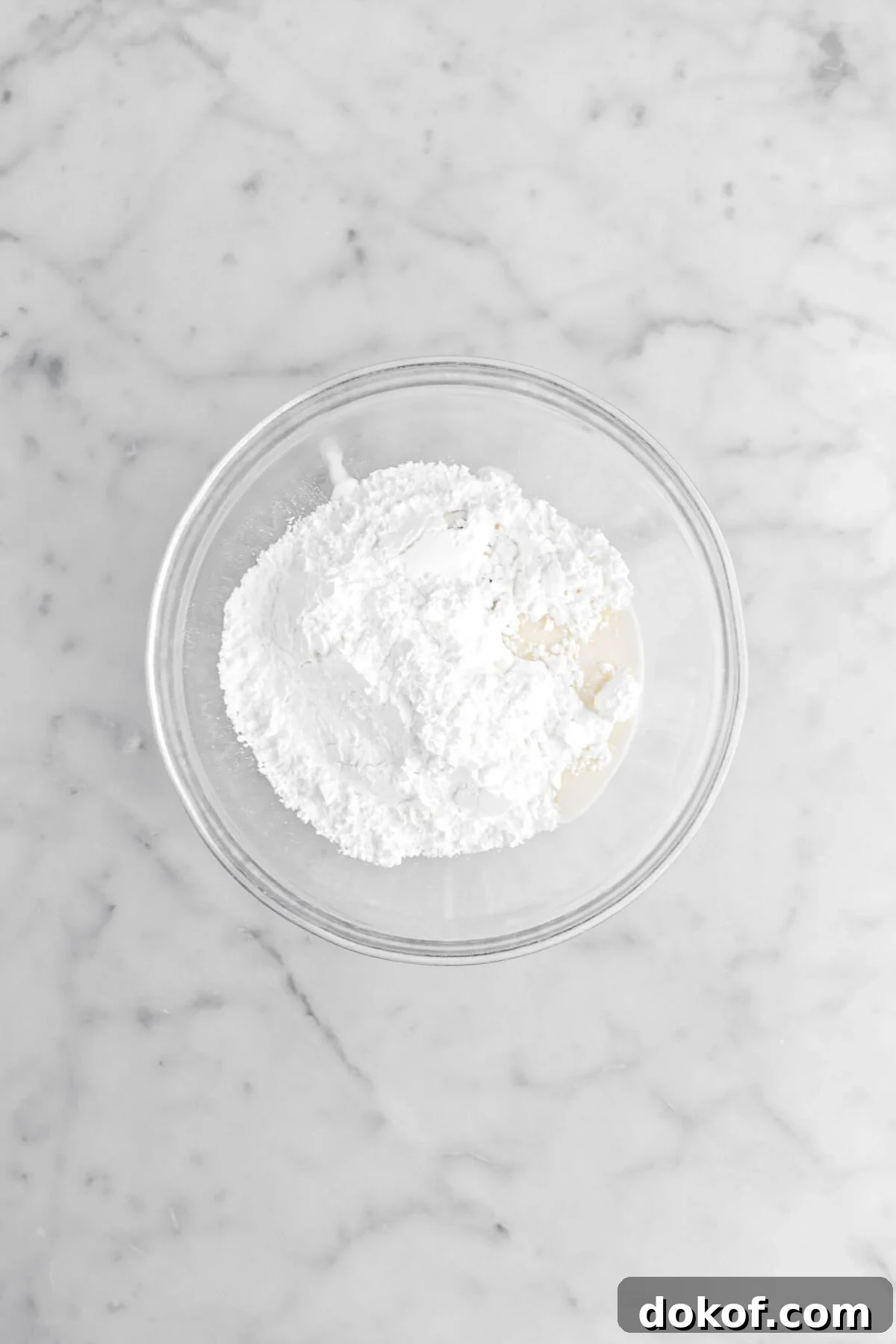 powdered sugar, milk, and vanilla in glass bowl.