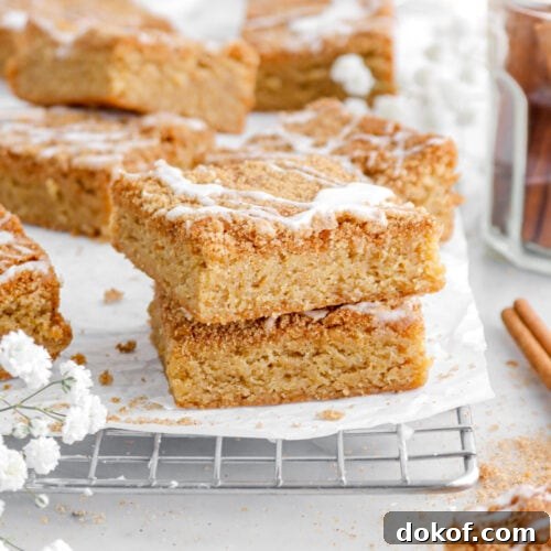 two stacked blondies on cooling rack with more behind.