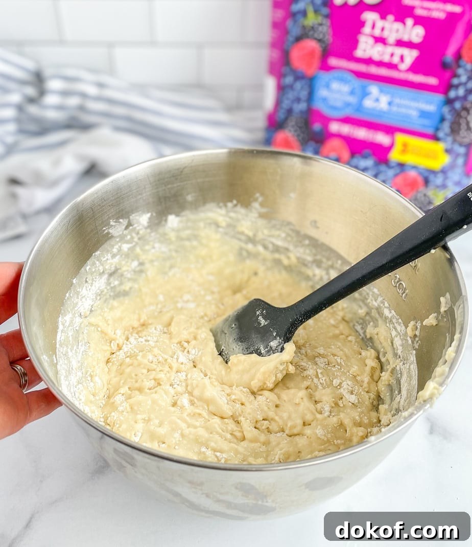 The batter should be lumpy with streaks of flour still showing before adding the frozen mixed berries