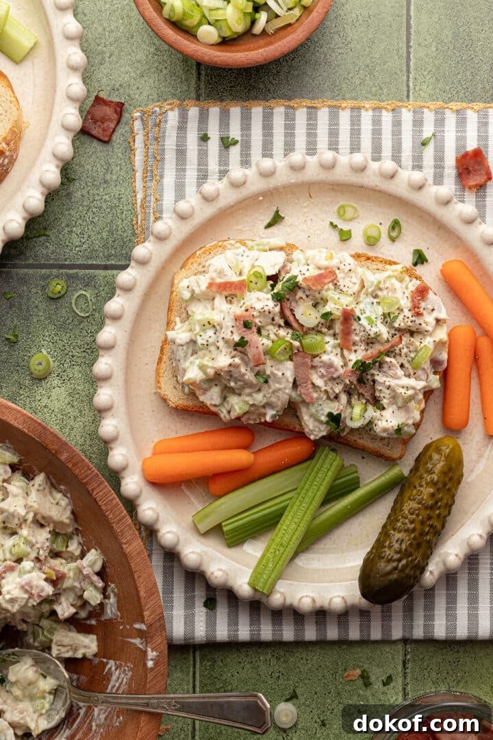 Ranch chicken salad on open-faced toast, served with sliced veggies and a pickle.