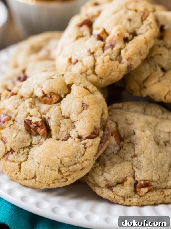 Butter pecan cookies piled onto a white plate.