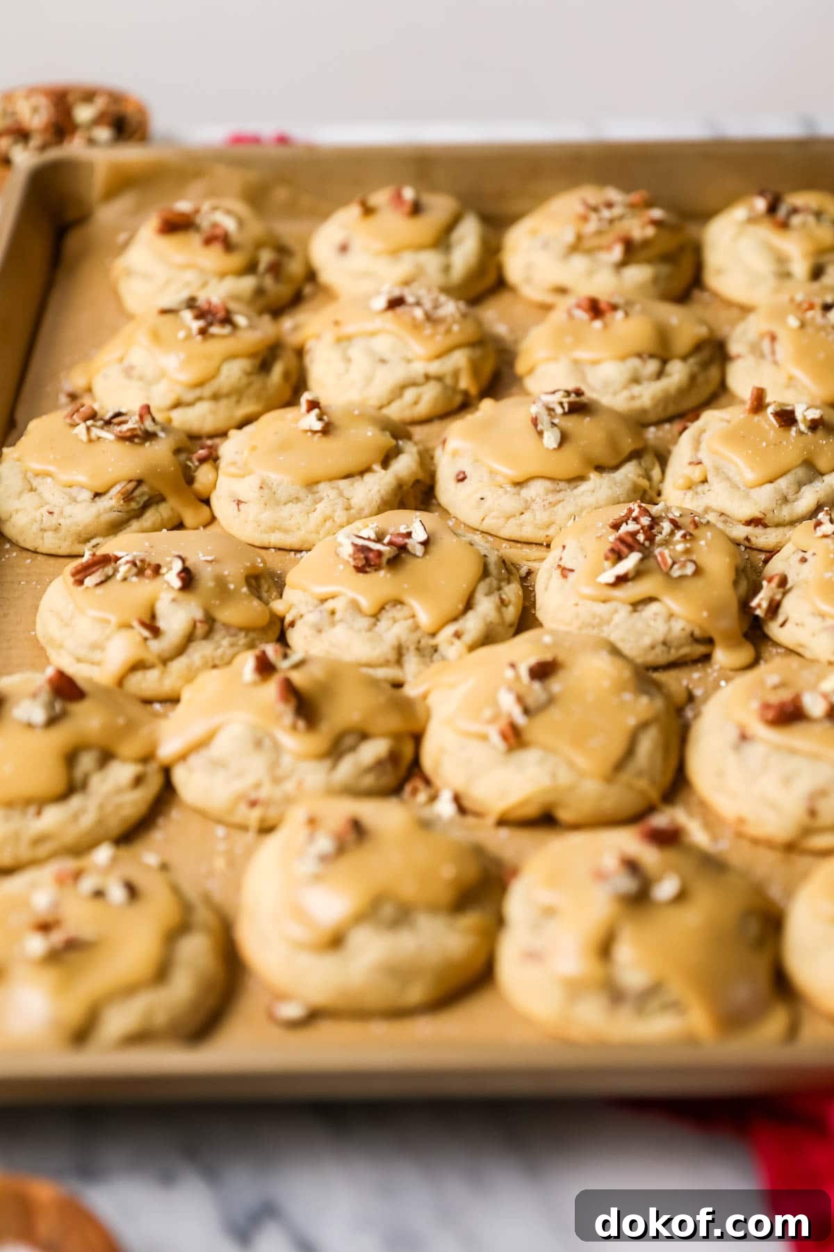 Rows of praline cookies topped with pecan pieces.