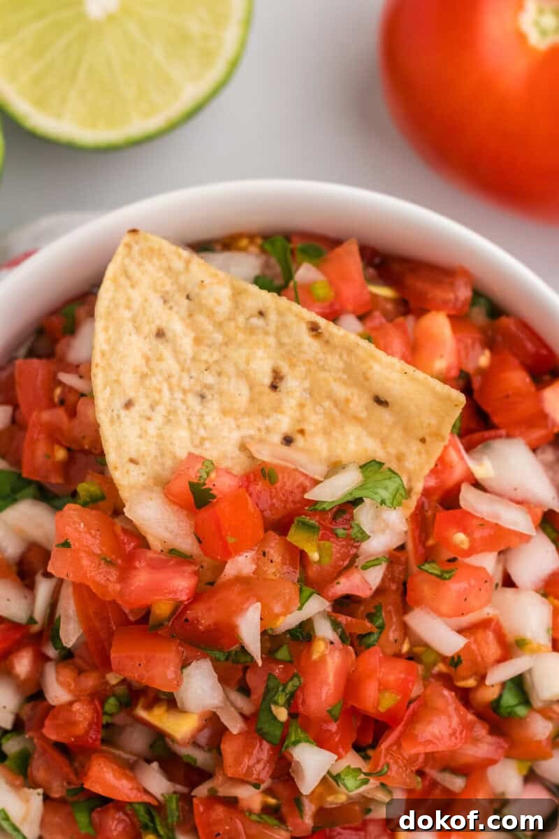 Authentic Pico de Gallo Recipe: Fresh Mexican Salsa Tutorial 8 closeup of dipping a tortilla chip into the Pico de Gallo.