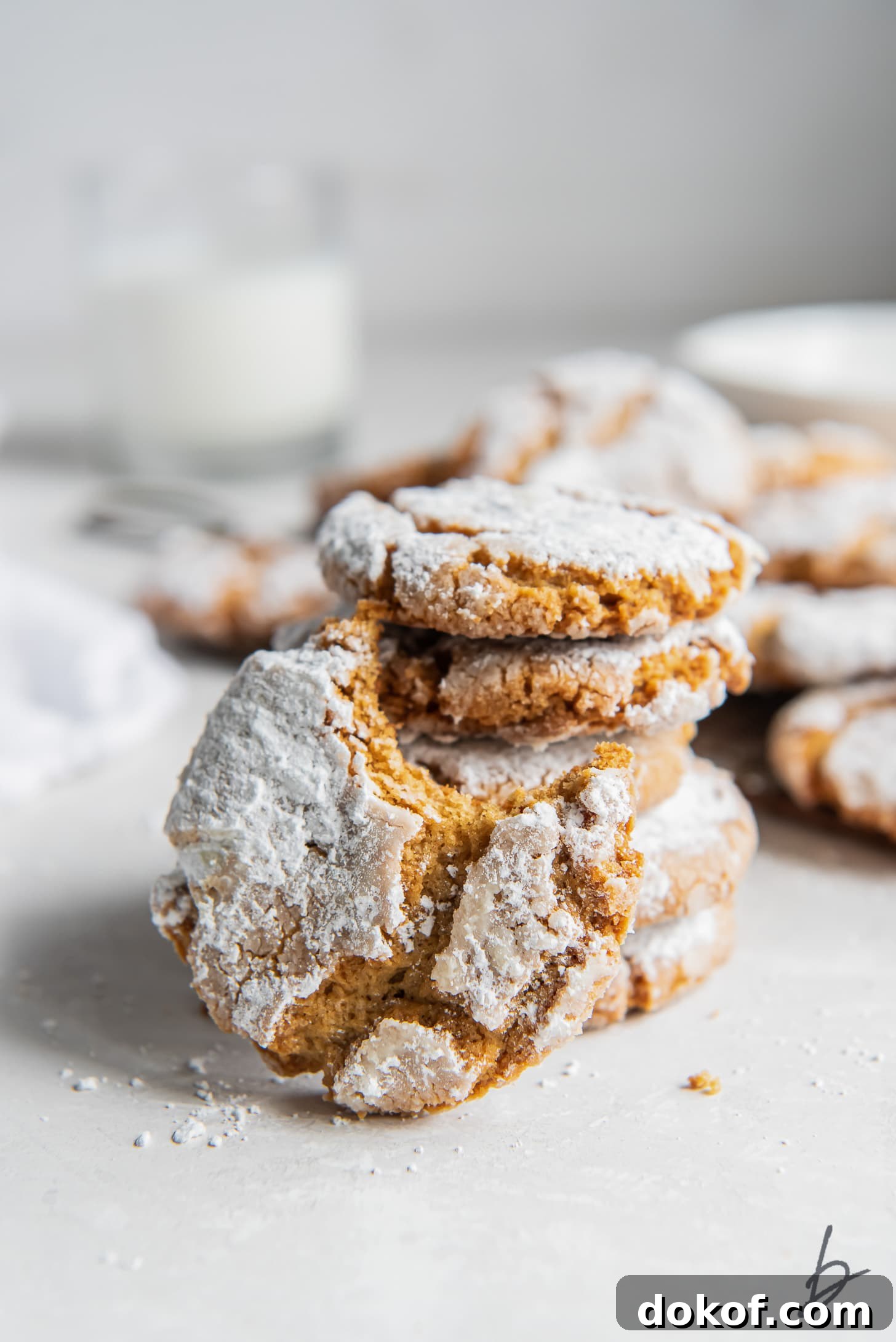 peanut butter crinkle cookie with a bite leaning on stack of cookies