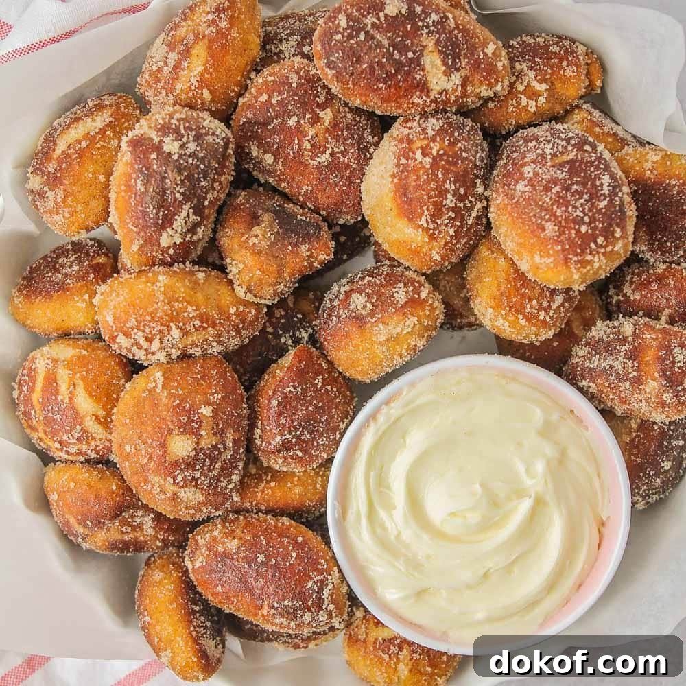 This copycat recipe for Auntie Anne's Cinnamon Sugar Pretzel Bites makes pretzels that are super soft on the inside and bursting with cinnamon sugar flavor on the outside! Bite sized cinnamon sugar pretzels with a side of cheesecake dip