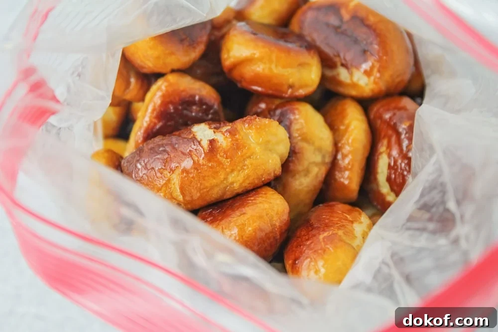 This copycat recipe for Auntie Anne's Cinnamon Sugar Pretzel Bites makes pretzels that are super soft on the inside and bursting with cinnamon sugar flavor on the outside! Cinnamon pretzel bites being coated in cinnamon sugar