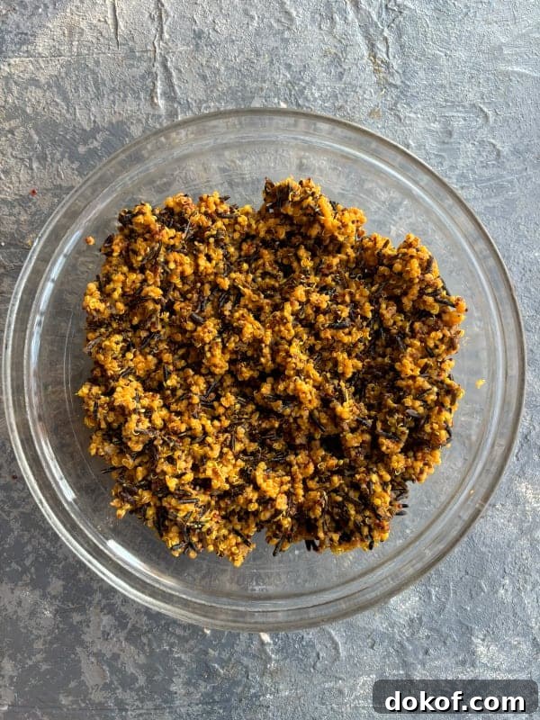 overhead image of a glass mixing bowl filled with a mixture of quinoa and wild rice