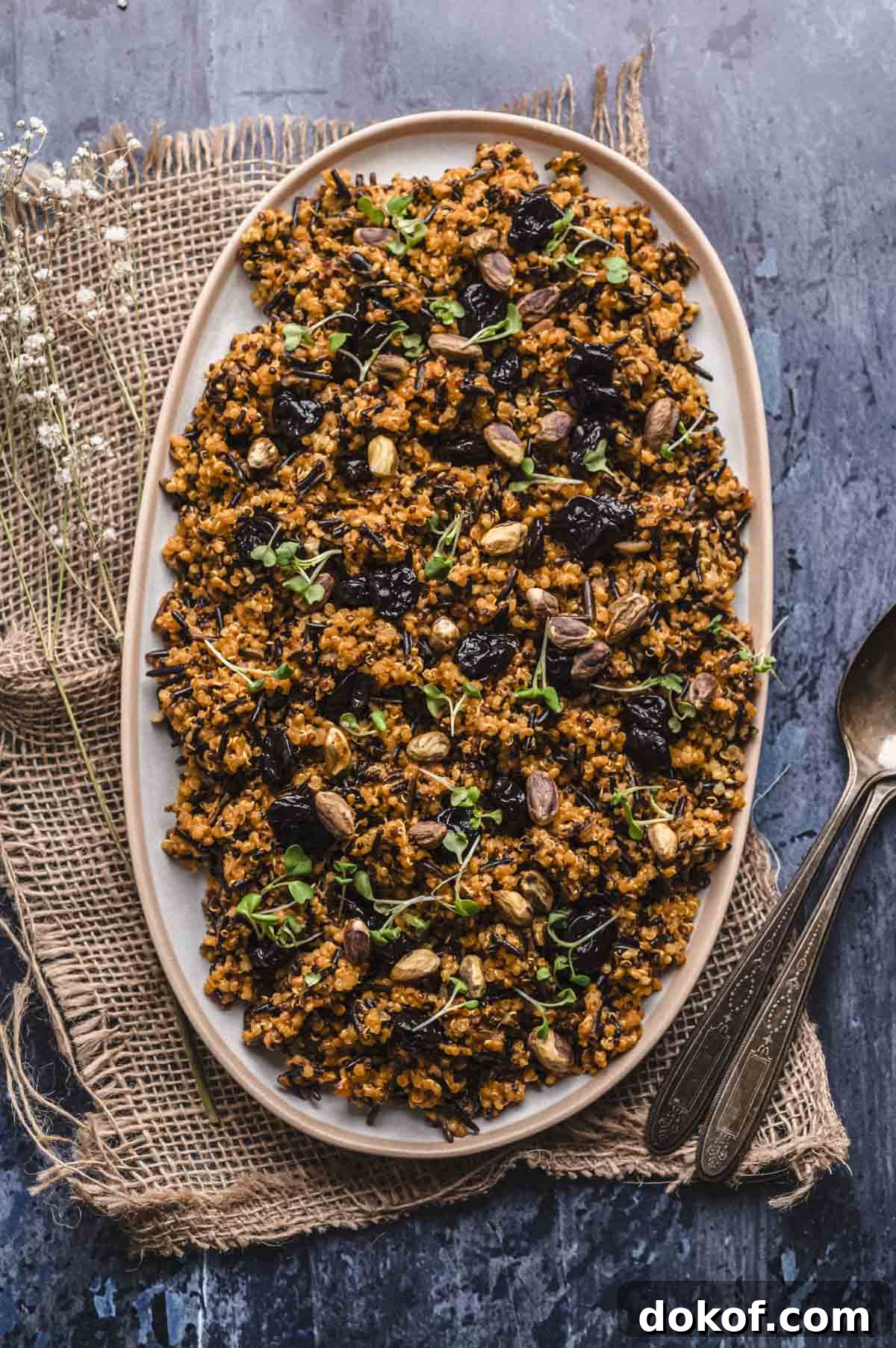 overhead image of an oval platter with a wild rice recipe mixed with pistachios and cherries.