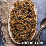 overhead image of an oval platter with a wild rice recipe mixed with pistachios and cherries.