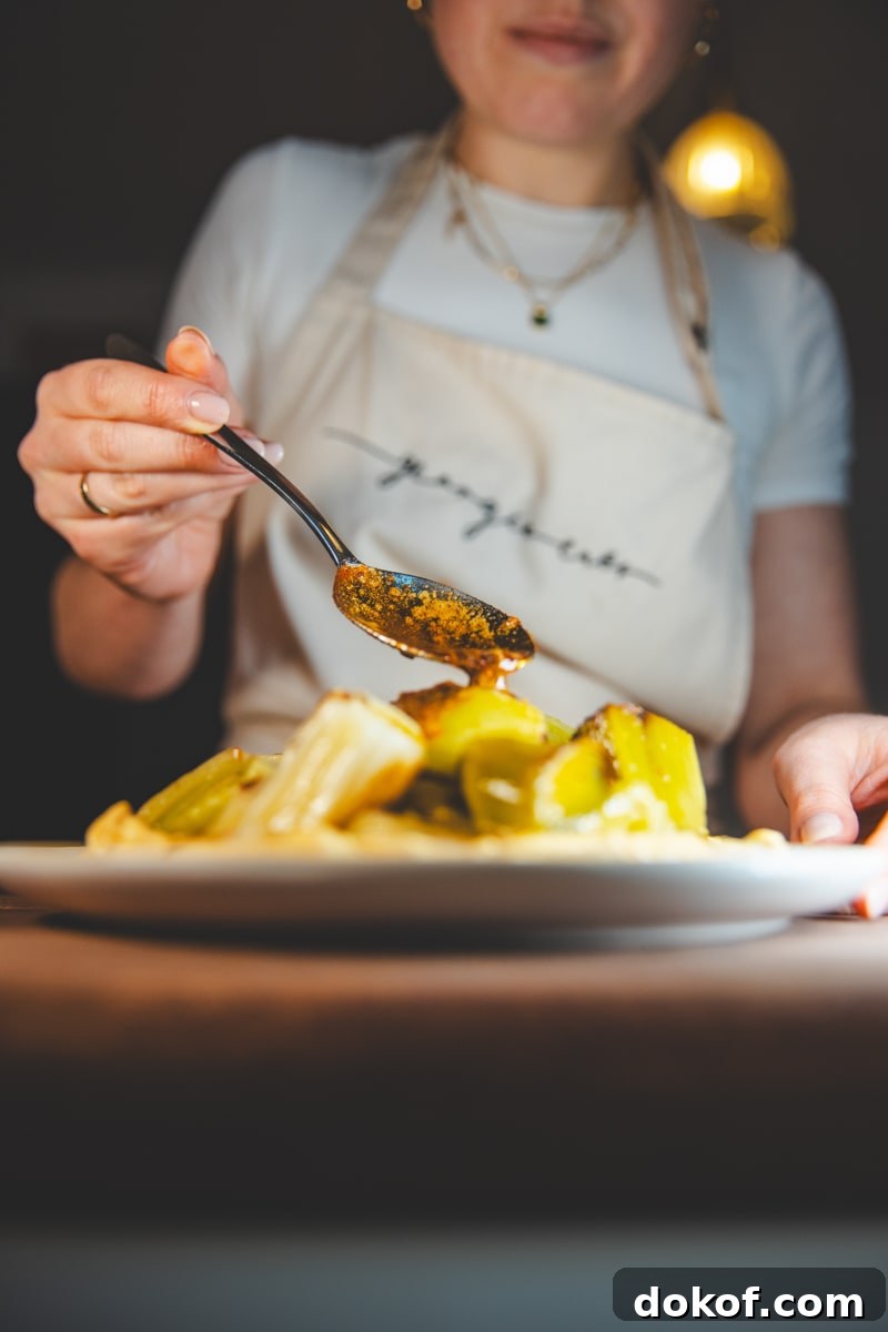 Spooning the tempering butter over Braised Leeks with Lime Pickle Yoghurt - Georgie Eats