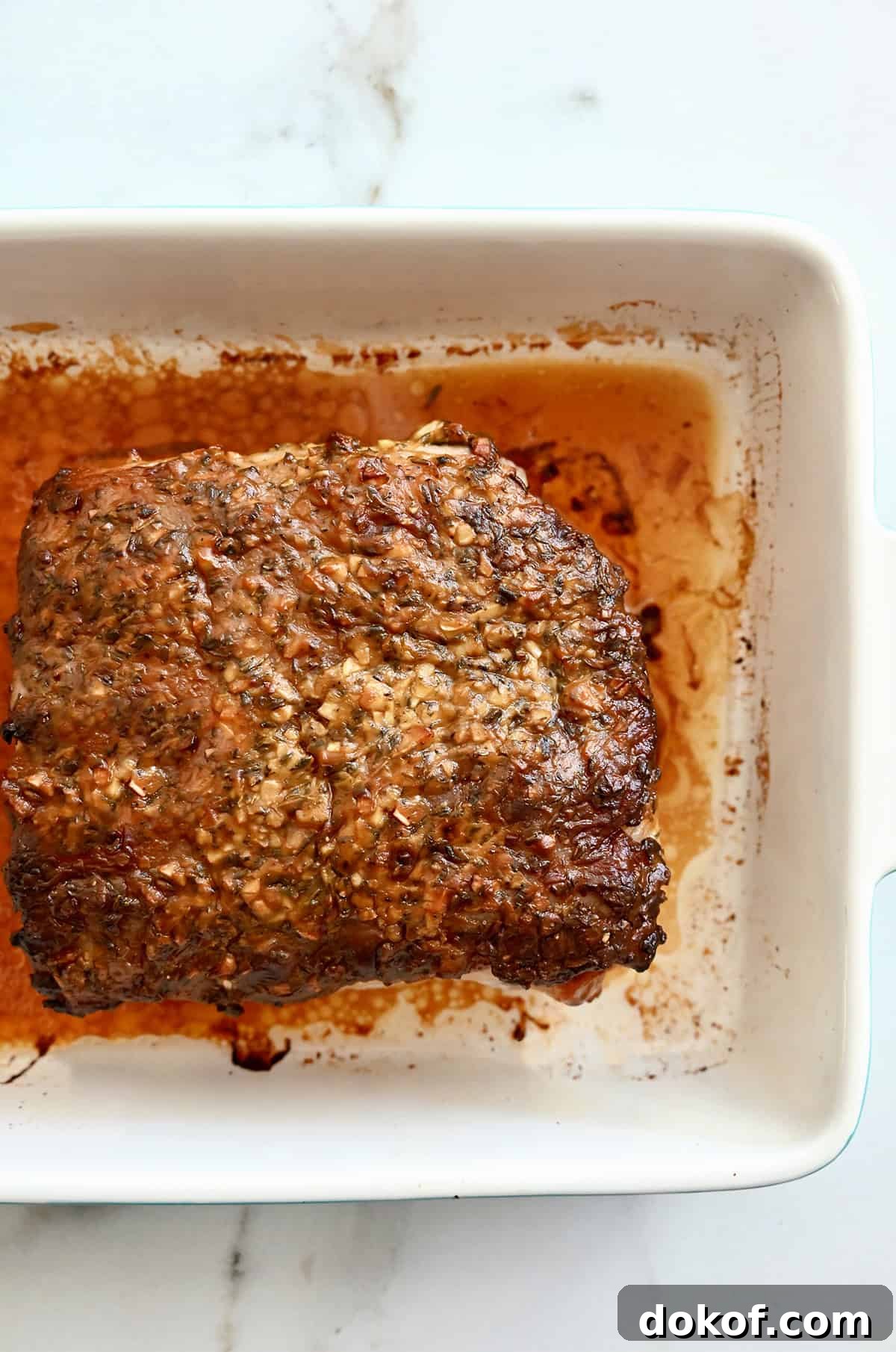 Roasted pork in a white baking dish.