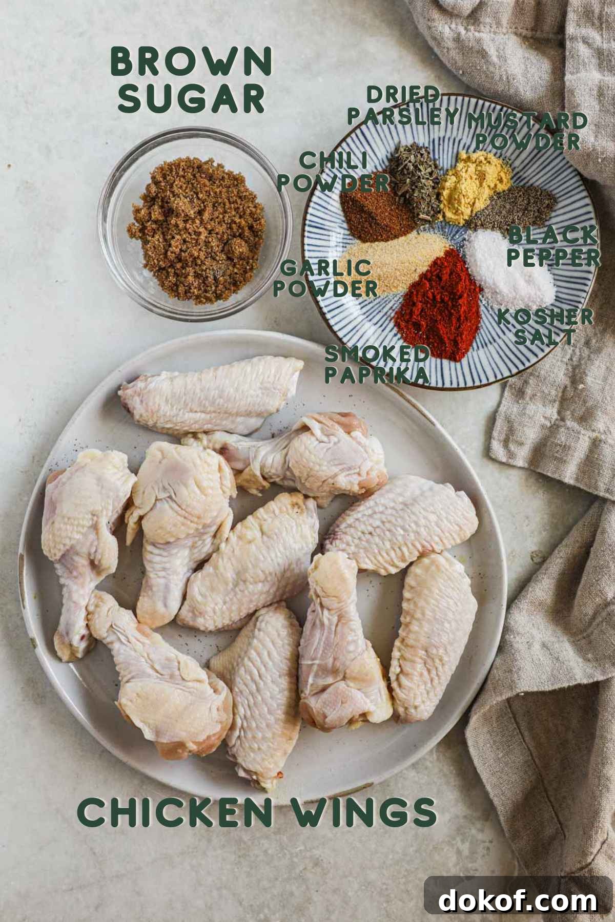 Ingredients to make baked dry rub chicken wings, chicken flats and drummettes, brown sugar, parsley, mustard powder, chili powder, garlic powder, smoked paprika, black pepper, kosher salt.