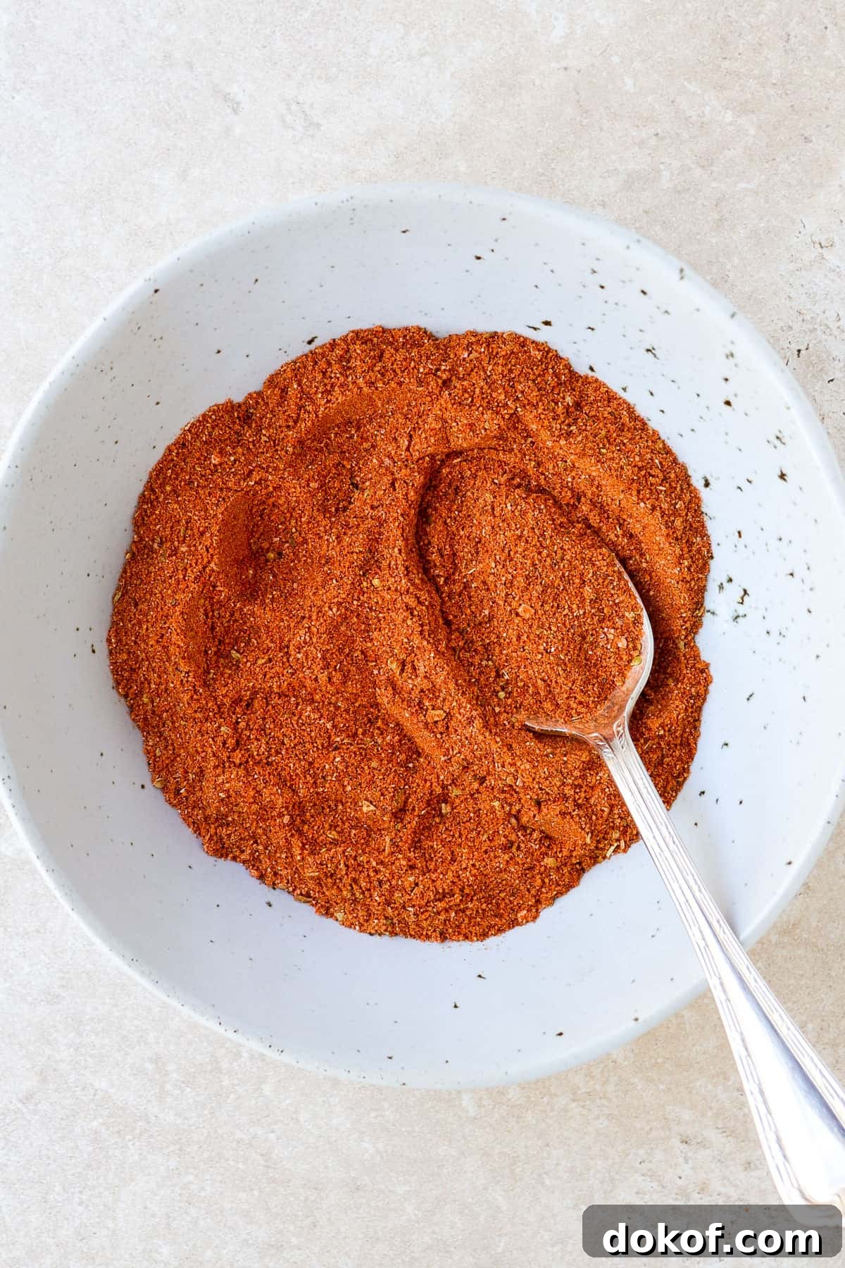 Homemade seasoning in a bowl with a spoon.