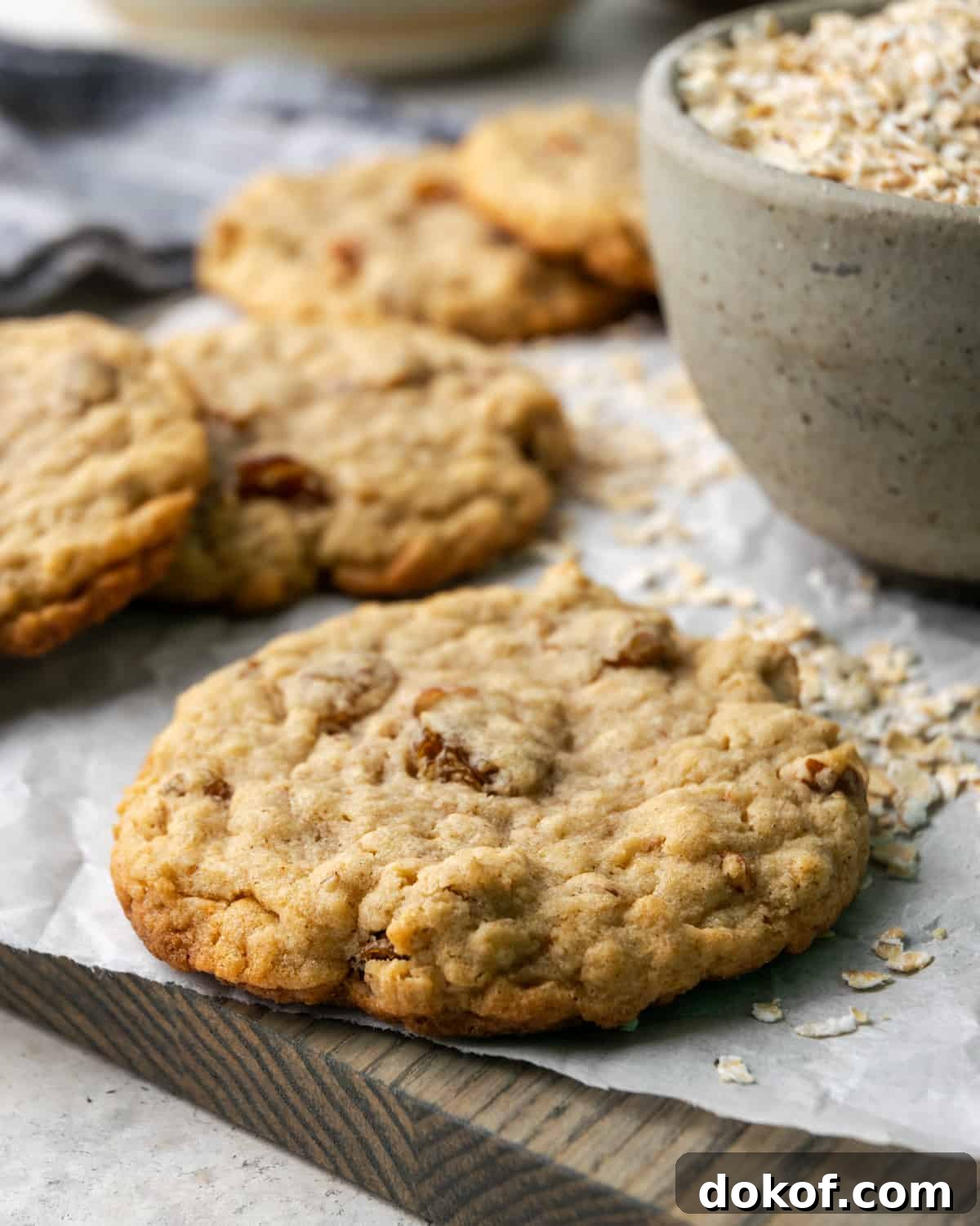 Five gluten free oatmeal cookies scattered on a cutting board.