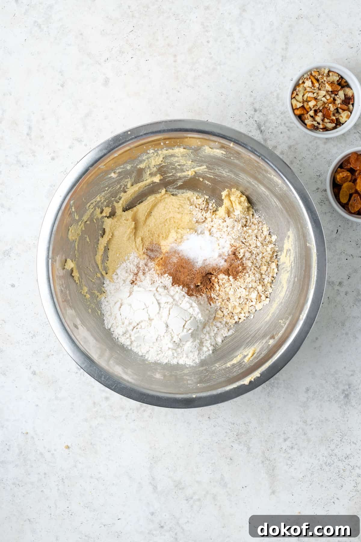 Gluten free flour, oats, cinnamon, baking soda and salt added to the partially mixed cookie dough. 