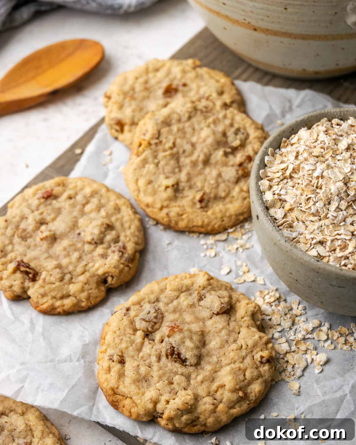Five gluten free oatmeal raisin cookies scattered on a white table. 