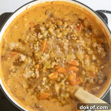 Lentil soup simmering in a pot.