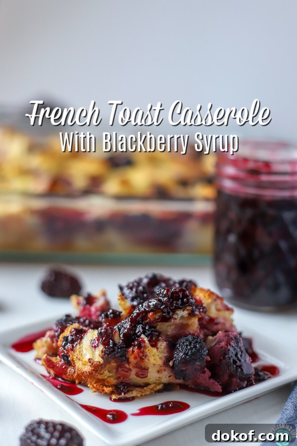 Slice of French Toast Casserole with Blackberries covered with blackberry syrup and a baking dish and jar of blackberry syrup in the back