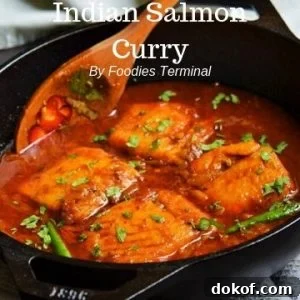 Indian Salmon curry in an iron wol with a wooden spatula