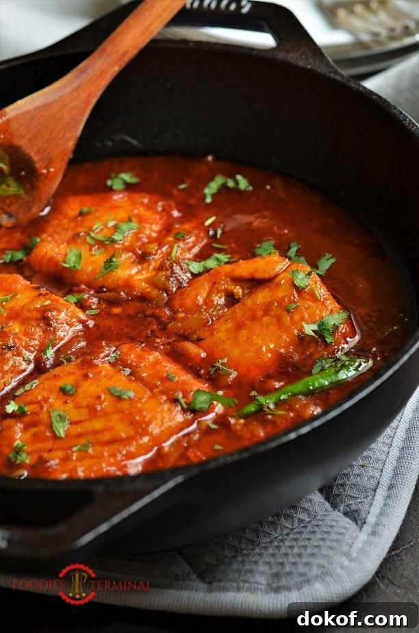 Indian style Salmon curry garnishe with cilantro in a black wok