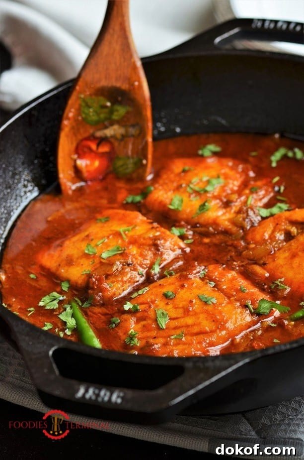 Easy Salmon curry in a red sauce served in an iron black wok