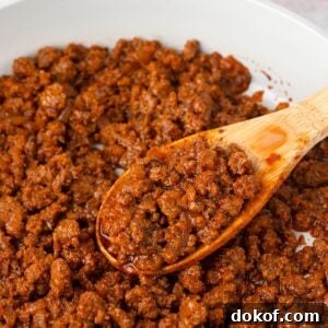 Homemade Taco Meat in a skillet with a wood spoon.