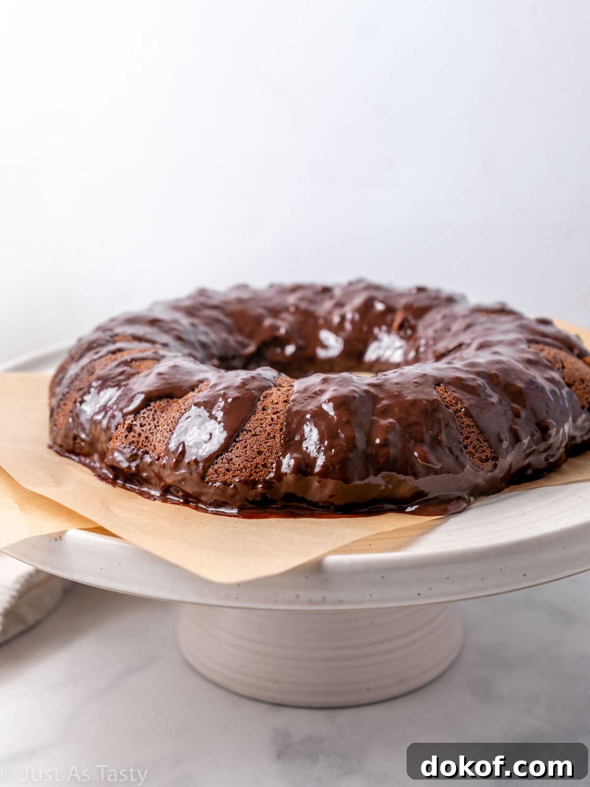 Chocolate bundt cake with sour cream on a cake stand.