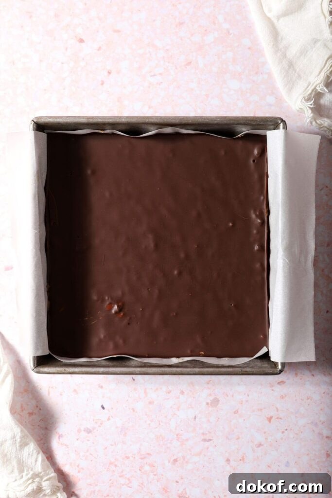 Chilled peanut butter bars topped with chocolate before slicing