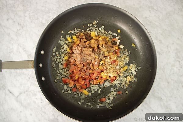 Peppers, garlic and spices added to onions