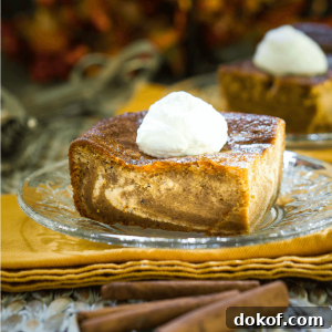 Creamy Pumpkin Cheesecake Swirl Bars Recipe 5 A piece of Pumpkin cheesecake with swirls of cream cheese filling running through it and topped with whipped cream sits on a glass plate over a glass plate on a gold napkin. Cinnamon sticks sit in the foreground and a second slice sit in the background.