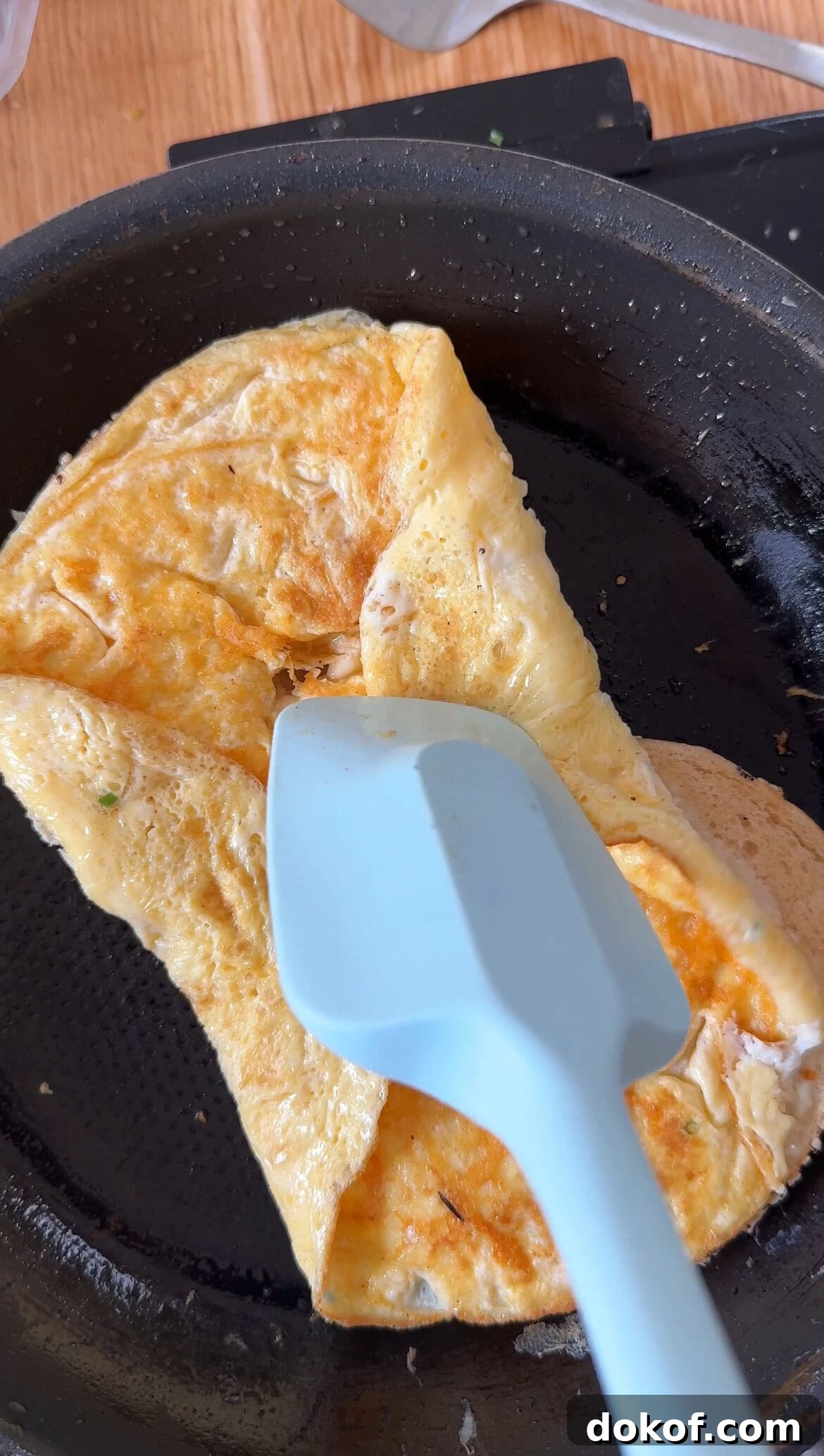 Morning Bagel Sandwich Recipes for Quick, Flavorful Breakfasts 7 folding egg into a breakfast bagel sandwich.