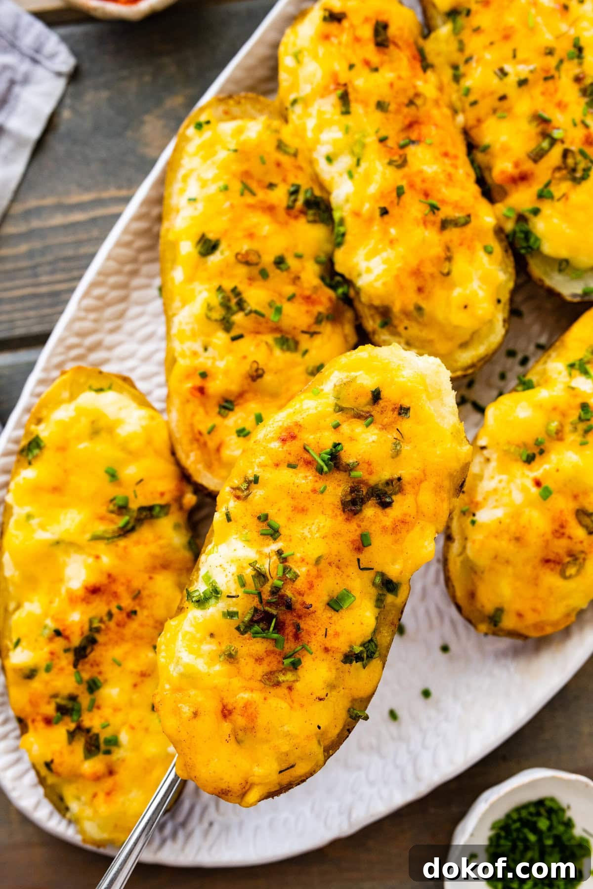 Best Twice Baked Potatoes Recipe on a white serving platter. Cheese is melty.