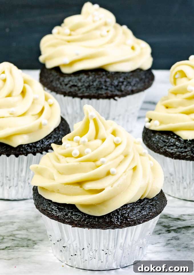 four Guinness Dark Chocolate Cupcakes with Irish Cream Cream Cheese Frosting in silver wrappers