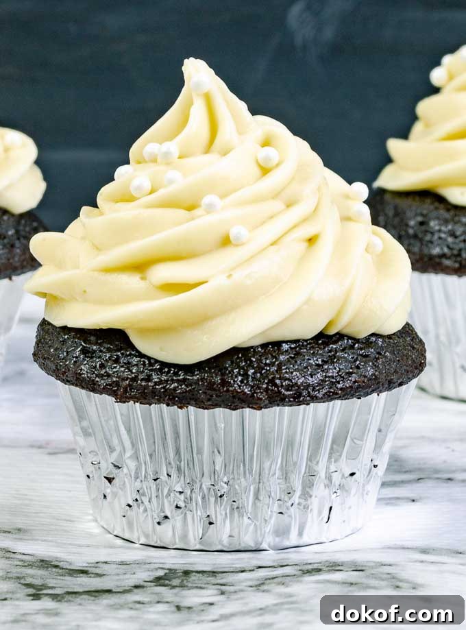 close up of a Guinness Dark Chocolate Cupcake with Irish Cream Cream Cheese Frosting in a silver wrapper