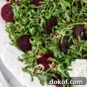 Roasted beet salad on a platter next to a napkin.