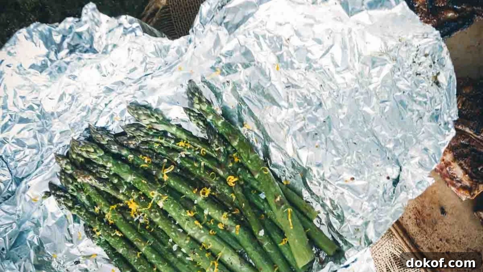 Grilled asparagus in foil cooked until tender with lightly charred tips.